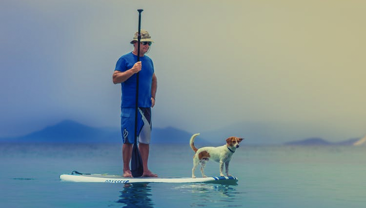 man and dog in lake